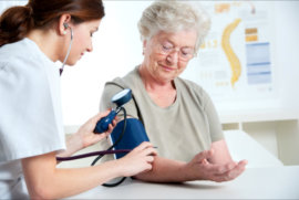 nurse checking patient’s blood pressure